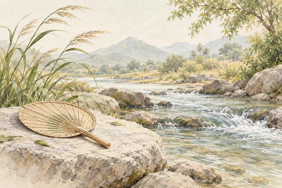 Woven fan beside a flowing stream